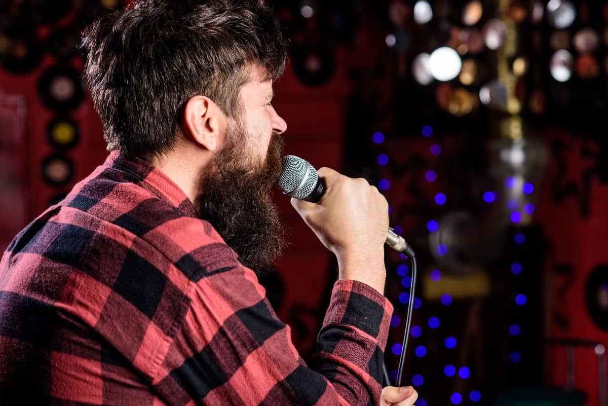 A man in recovery singing karaoke at a sober bar in Arizona.