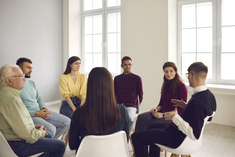 A group of people supporting one another during a therapy session.